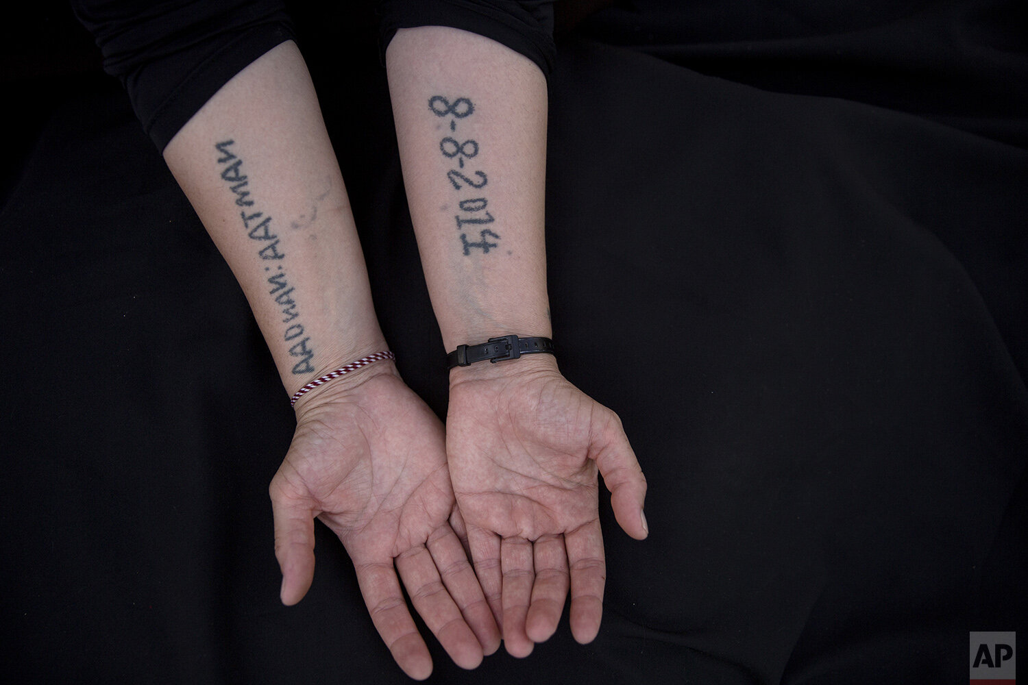  In this Thursday, Aug. 29, 2019 photo, Leila Shamo displays tattoos she made while enslaved by Islamic State militants at her home near Khanke Camp, near Dohuk, Iraq. Shamo, 34, has used her breast milk, charcoal ash and a needle to write the names 