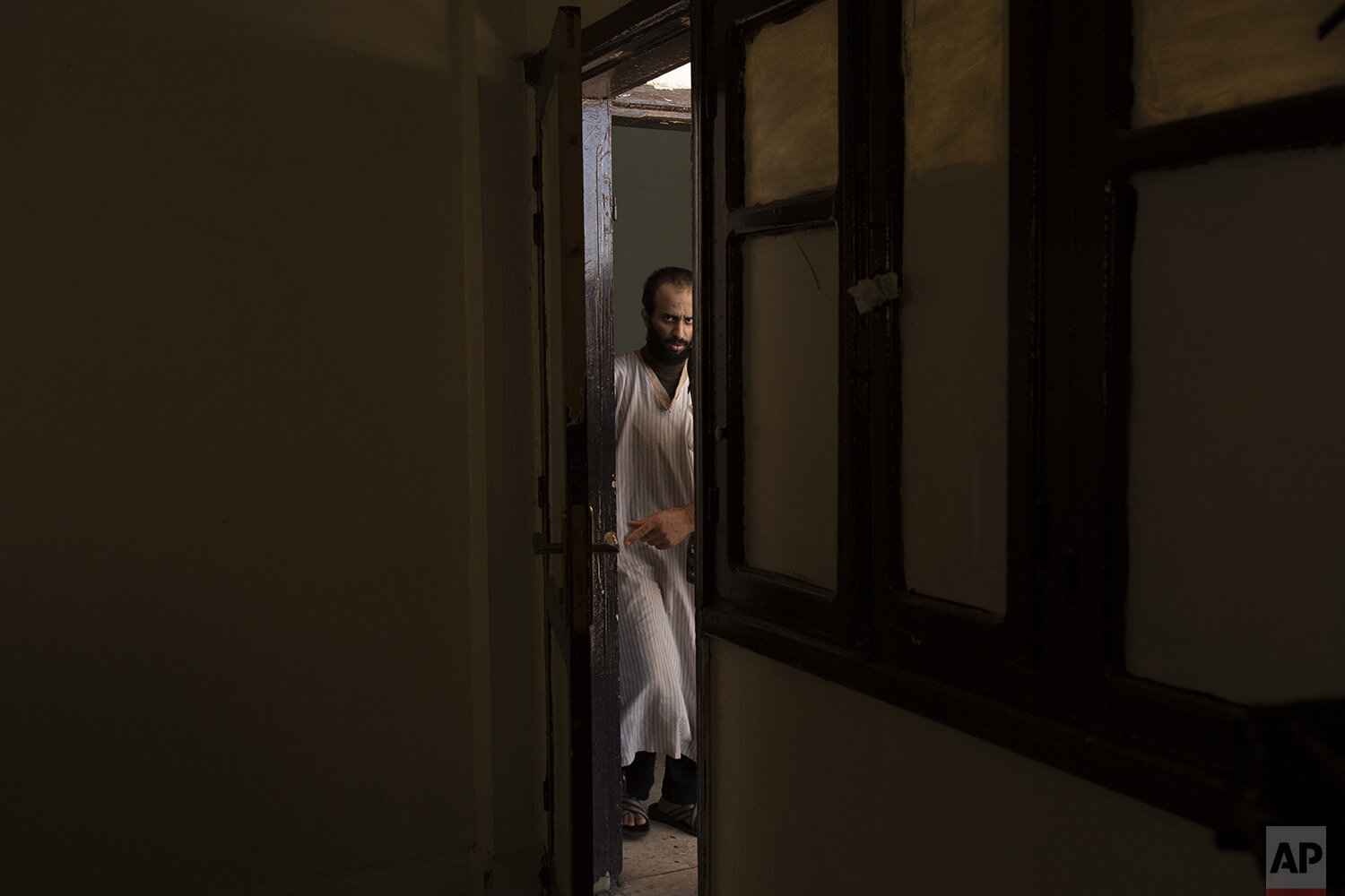  In this Sept. 4, 2019, photo, Abdul-Rahman al-Shmary, a 24-year old Saudi Islamic State member who traded in Yazidi slaves and has been in a Syrian Kurdish-run prison since 2017, is led by guards to an interview in Rmeilan, northeast Syria. He dismi