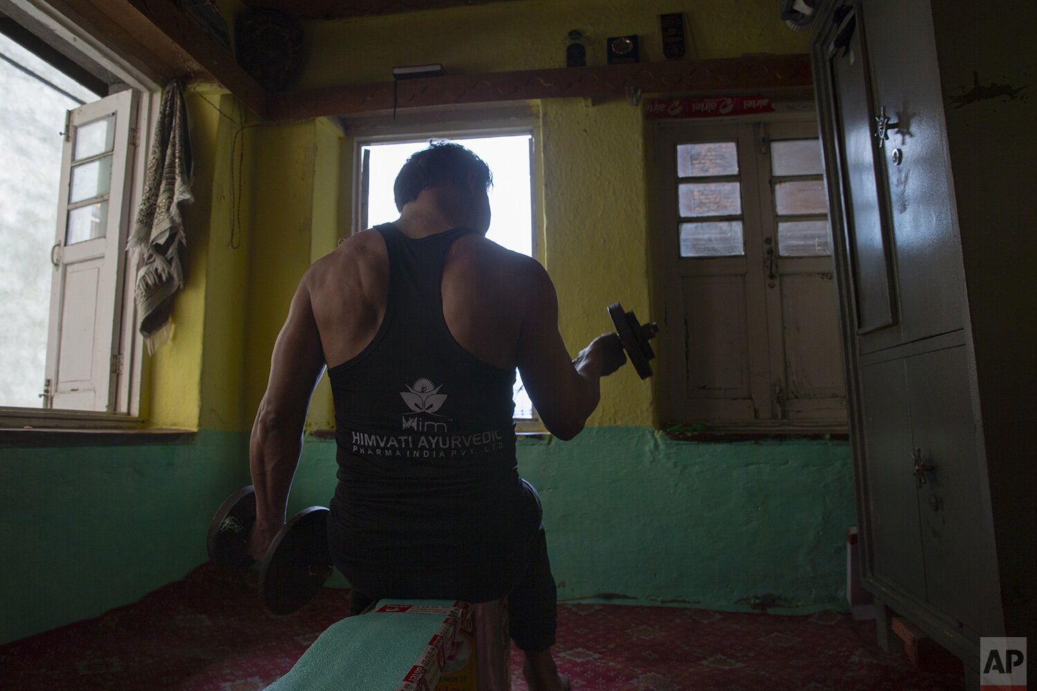  Weightlifter Bashir Ahmed practices at his home in Srinagar, Indian controlled Kashmir, April 21, 2020. Like many other athletes, the coronavirus pandemic has restricted Ahmed to his home. But lockdown for the 7 million residents of Kashmir is nothi