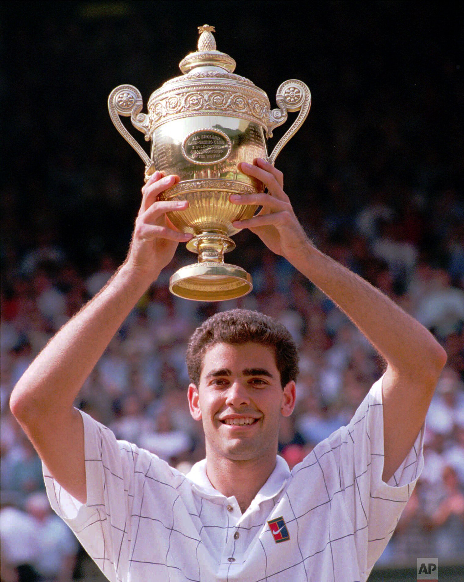  Pete Sampras holds his trophy, after defeating Boris Becker to win the men's singles final on Centre Court at Wimbledon, Sunday, July 9, 1995. Sampras defeated Becker 6-7 (5-7), 6-2, 6-4, 6-2 to win his third consecutive championship. (AP Photo/Dave
