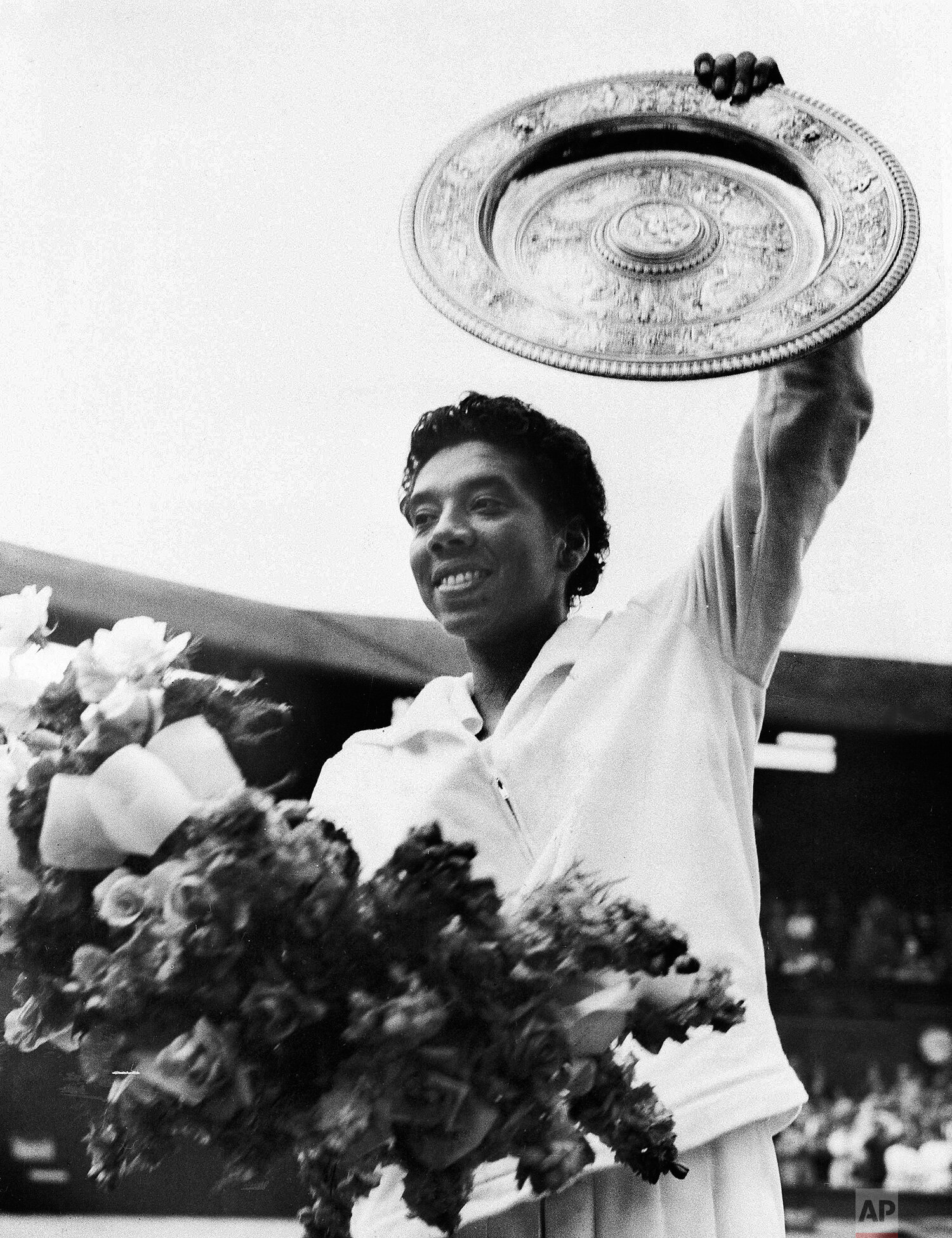  New York's Althea Gibson waves the winner's plate aloft after she defeated Britain's Angela Mortimer in the women's singles tennis final at Wimbledon, England, July 5, 1958. It was the second straight Wimbledon championship for the 31-year-old Gibso