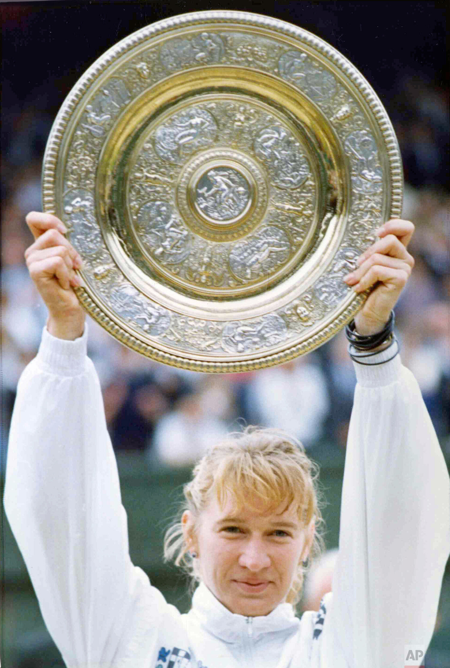  West Germany's Steffi Graf holds up the Championship Plate on the Centre Court at Wimbledon, London, July 9, 1989, after defeating Martina Navratilova for the second year in succession. (AP Photo/Dave Caulkin) 