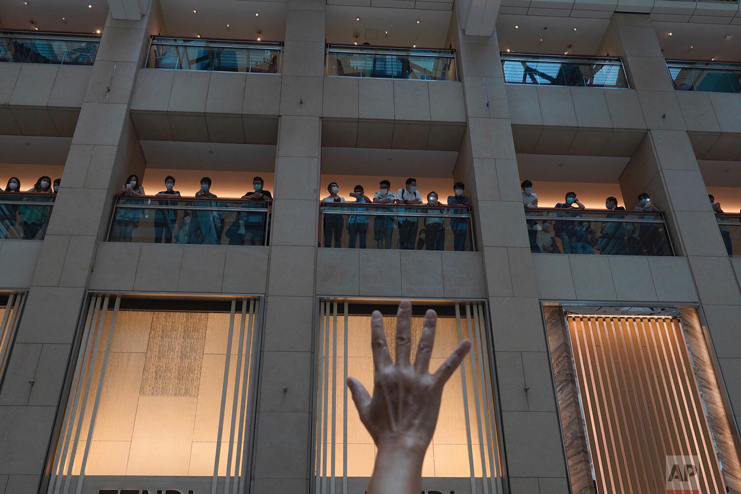  A protester gestures with five fingers, signifying the "Five demands - not one less" in a shopping mall during a protest against China's national security legislation for the city, in Hong Kong, Monday, June 1, 2020.  (AP Photo/Vincent Yu) 