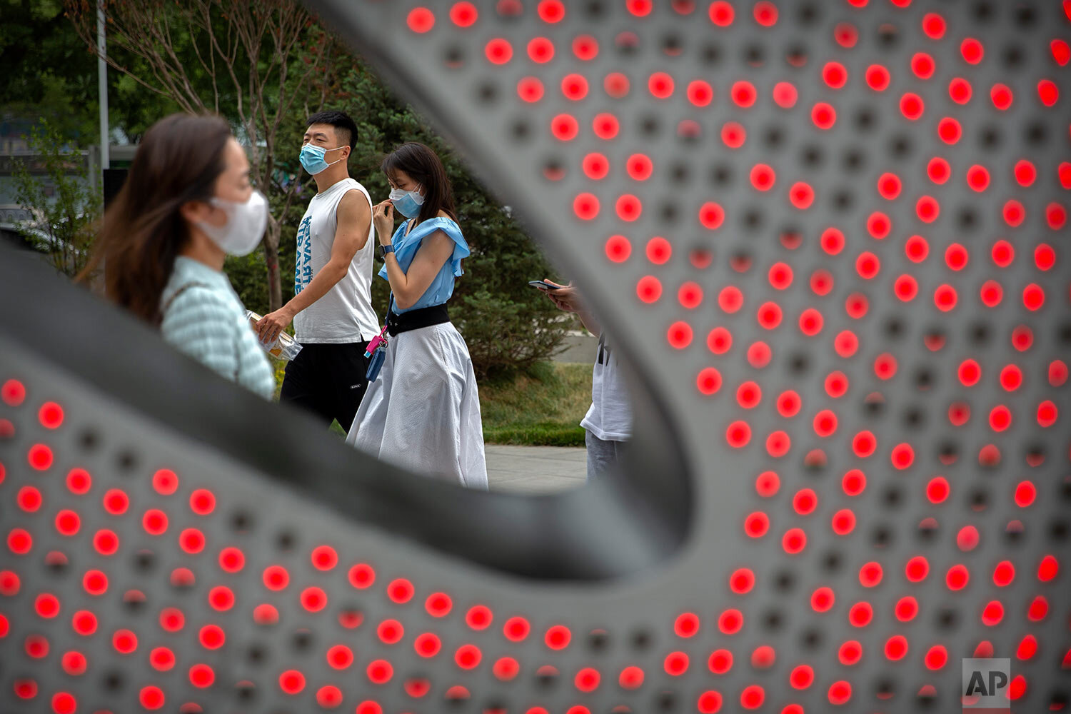  People wearing face masks to protect against the spread of the new coronavirus walk through a shopping and office complex in Beijing, Wednesday, June 24, 2020. (AP Photo/Mark Schiefelbein) 