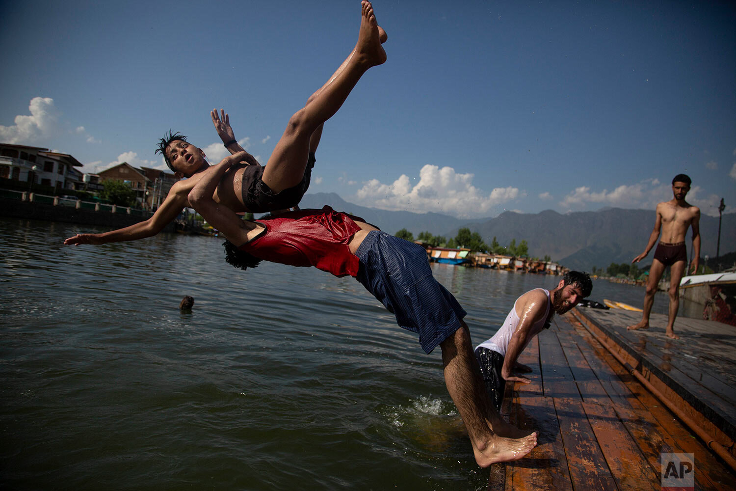  Kashmiri boys dive into the Dal Lake on a hot summer day in Srinagar, Srinagar, Indian controlled Kashmir, Thursday, June 25, 2020. (AP Photo/Mukhtar Khan) 