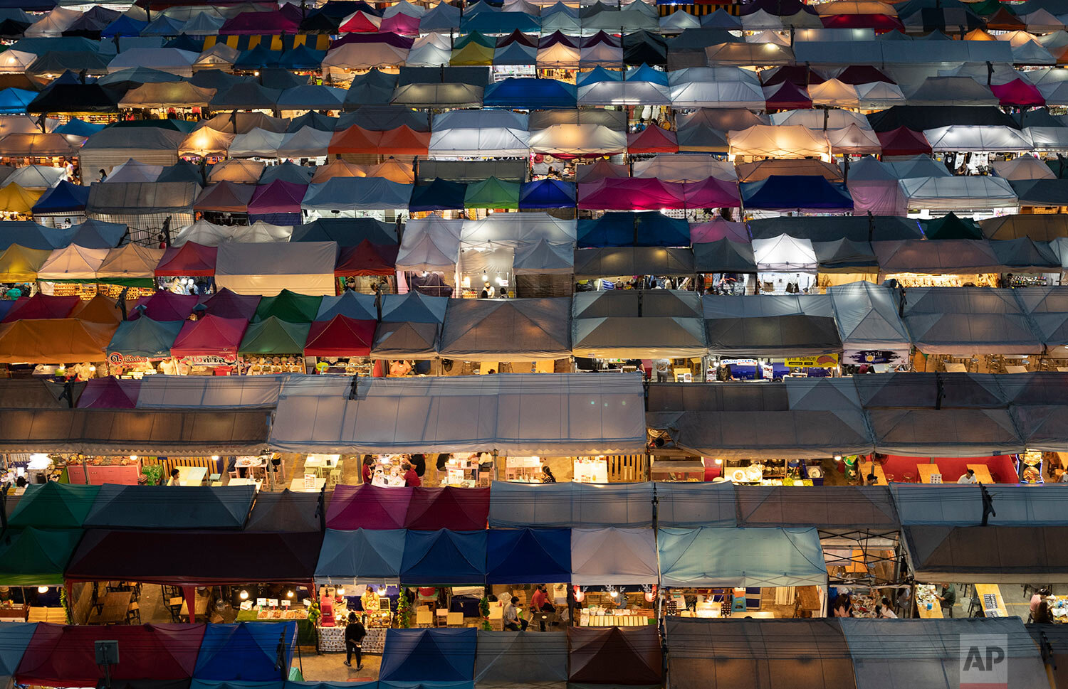  Tents of food stalls and other vendors are illuminated at Rot Fai Market in Bangkok, Thailand, Friday, June 19, 2020. (AP Photo/Sakchai Lalit) 