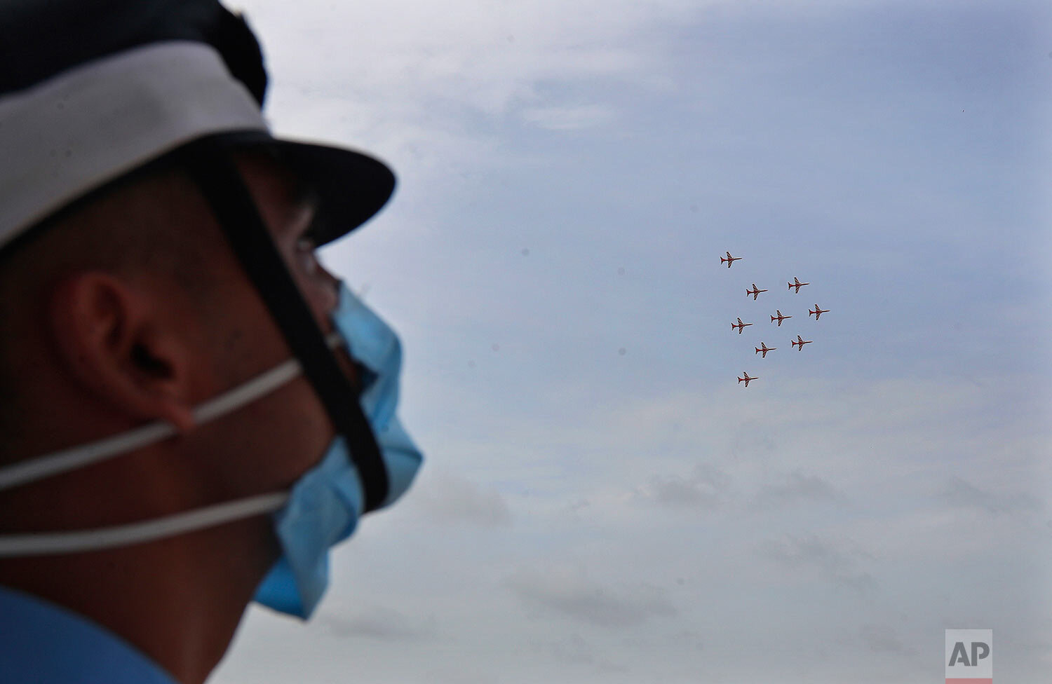  An Indian Air Force (IAF) cadet watches the Surya Kiran aerobatic team perform during a graduation parade at the Air Force Academy in Dundigal, on the outskirts of Hyderabad, India, Saturday, June 20, 2020. (AP Photo/Mahesh Kumar A.) 