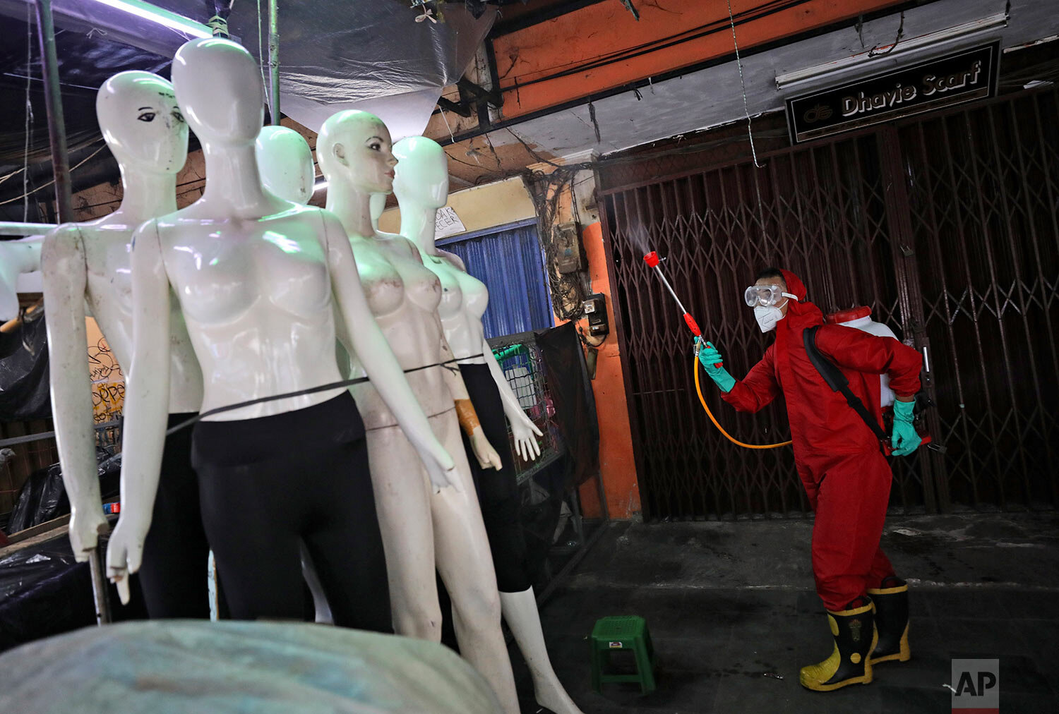  A fireman sprays disinfectant at mannequins as a precaution against the coronavirus  at Tanah Abang textile market in Jakarta, Indonesia, Thursday, June 4, 2020. (AP Photo/Dita Alangkara) 