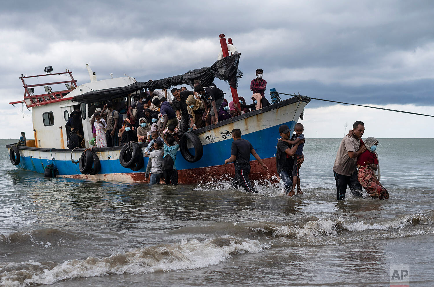  Local fisherman help ethnic-Rohingya people as they arrive on Lancok Beach, North Aceh, Indonesia, Thursday, June 25, 2020. (AP Photo/Zik Maulana) 