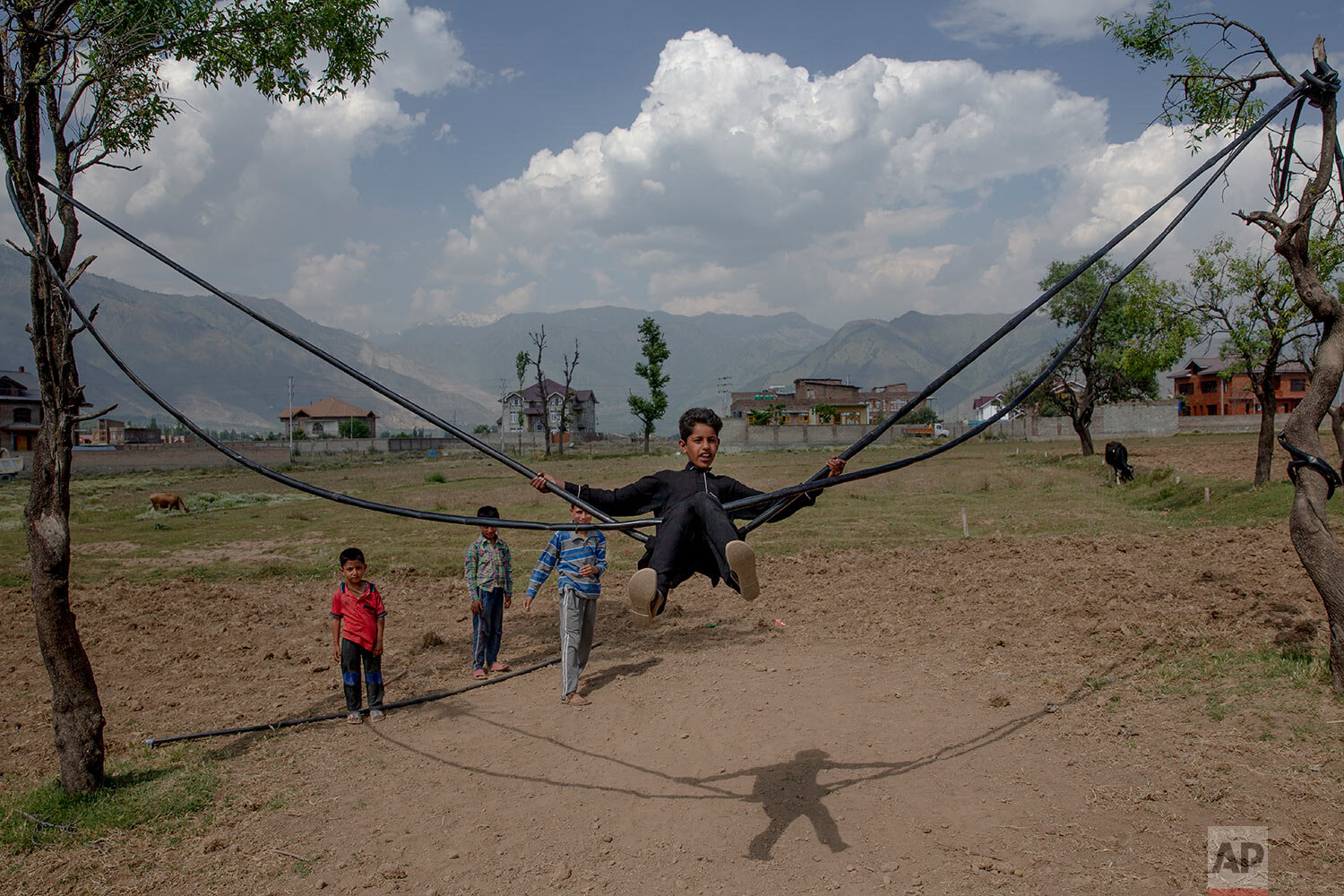  Kashmiri boys play on a makeshift swing on a hot summer day on the outskirts of Srinagar, Indian controlled Kashmir, Tuesday, June 16, 2020. (AP Photo/ Dar Yasin) 