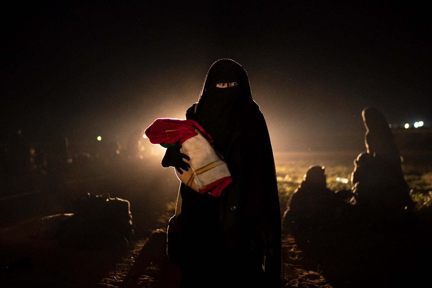  A woman who was evacuated out of the last territory held by Islamic State militants holds her baby after being screened by U.S.-backed Syrian Democratic Forces (SDF) in the desert outside Baghouz, Syria, Monday, Feb. 25, 2019. (AP Photo/Felipe Dana)