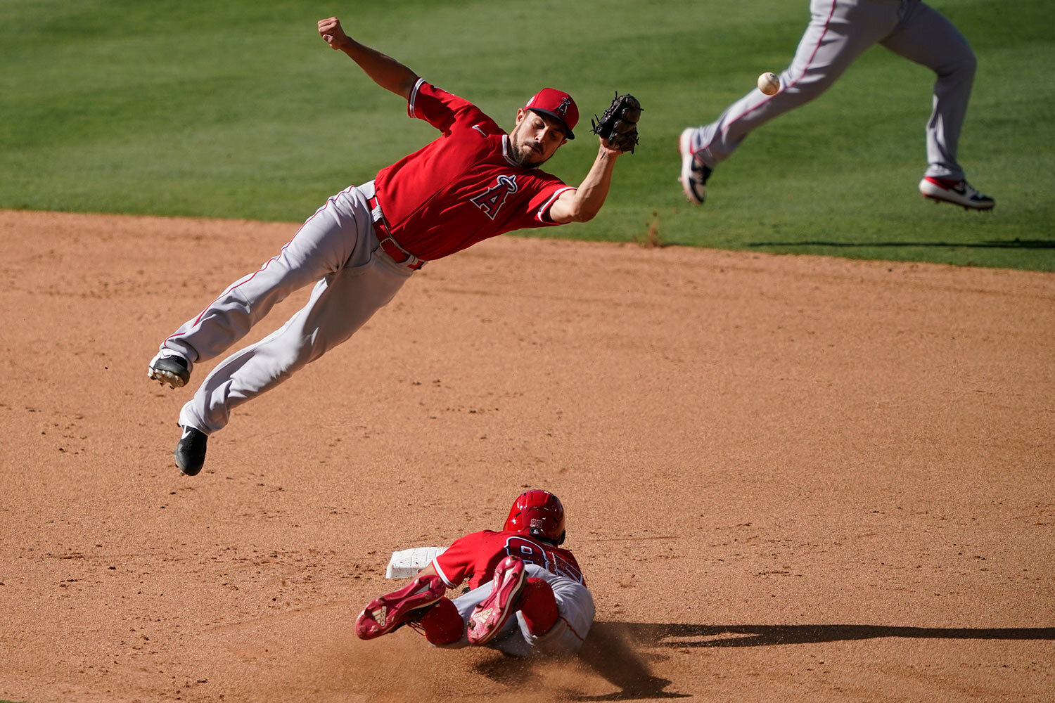  Los Angeles Angels infielder Elliott Soto, top, jumps to catch a ball over Jordyn Adams at second base during an intrasquad game at baseball practice at Angel Stadium on Wednesday, July 8, 2020, in Anaheim, Calif. (AP Photo/Ashley Landis) 