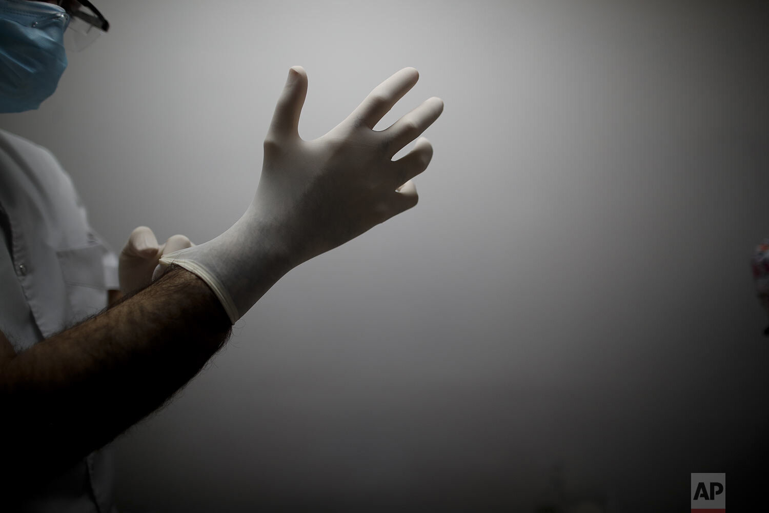  Dr. Matias Norte pulls on rubber gloves at a hospital during a government-ordered lockdown to curb the spread of the new coronavirus in Buenos Aires, Argentina, Saturday, July 18, 2020. (AP Photo/Natacha Pisarenko) 