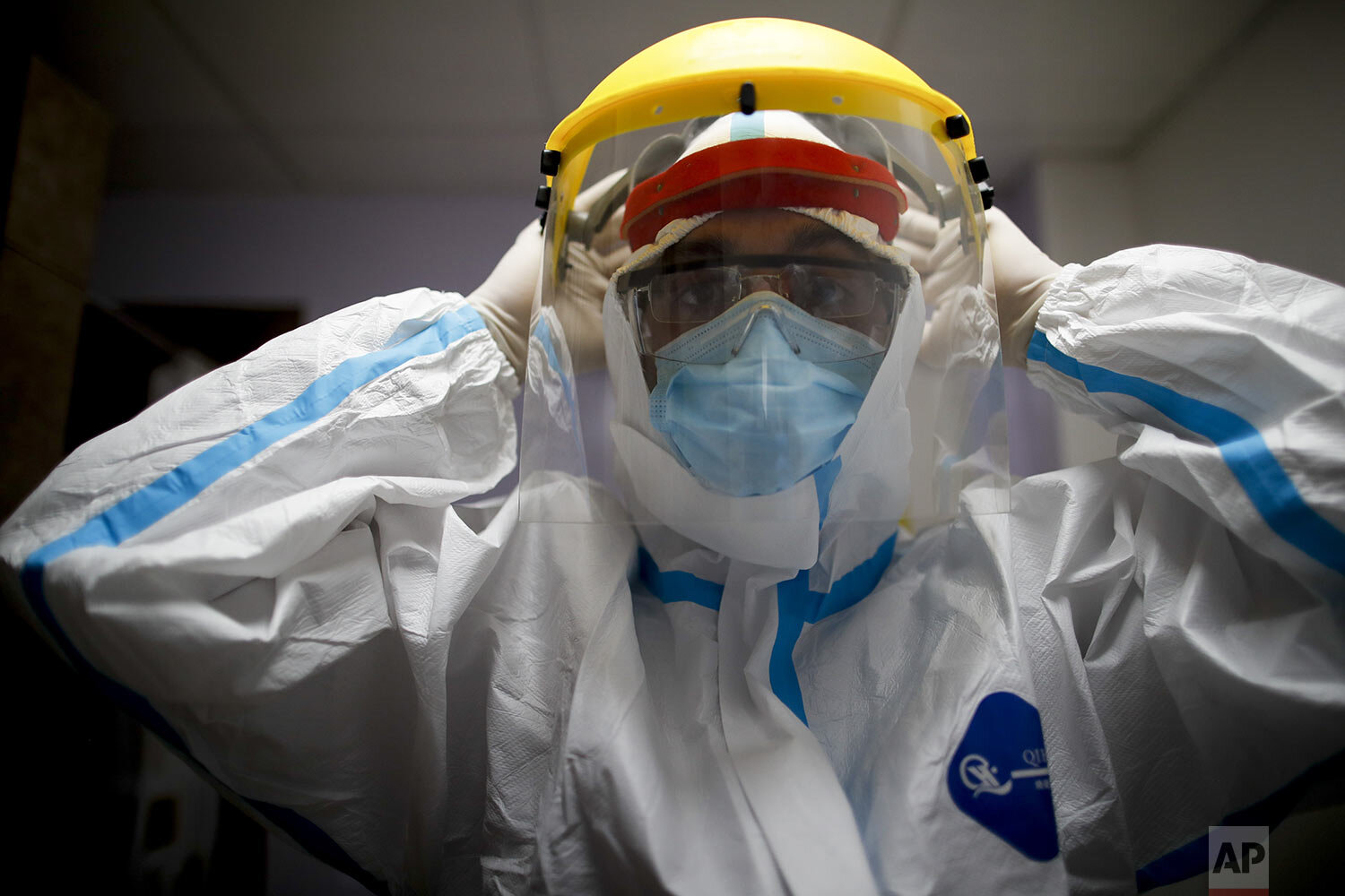  Dr. Matias Norte adjusts his face shield as he dresses in full protective gear at a hospital, one of three he visiting in Buenos Aires, Argentina, Saturday, July 18, 2020. (AP Photo/Natacha Pisarenko) 