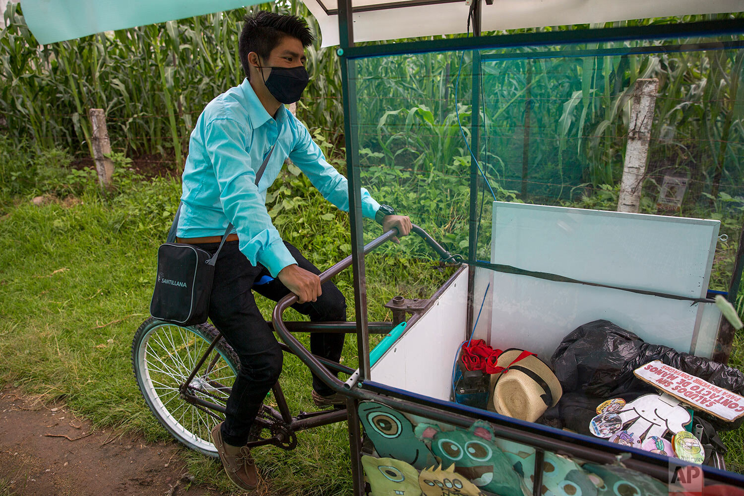  Teacher Gerardo Ixcoy pedals his adult tricycle converted into a mobile classroom past cornfields, in Santa Cruz del Quiche, Guatemala, Wednesday, July 15, 2020. When the novel coronavirus closed Guatemala's schools in mid-March, the 27-year-old inv