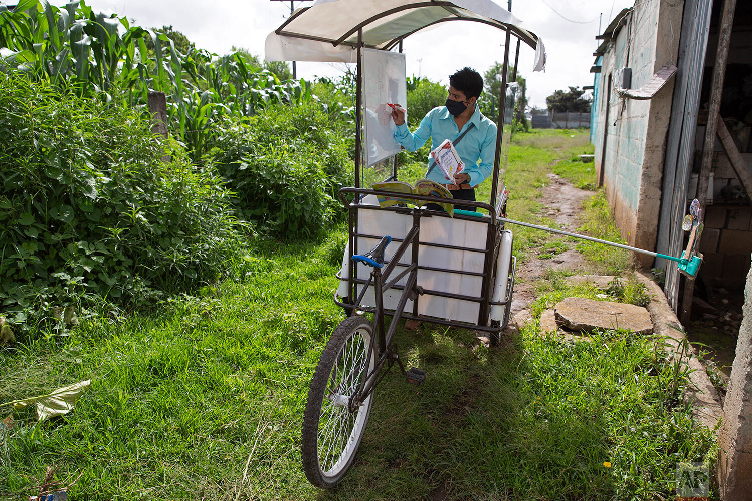  Teacher Gerardo Ixcoy conducts a math class from a secondhand, adult tricycle that he converted into a mobile classroom, in Santa Cruz del Quiche, Guatemala, Wednesday, July 15, 2020, amid the new coronavirus pandemic. The 27-year-old teacher deploy