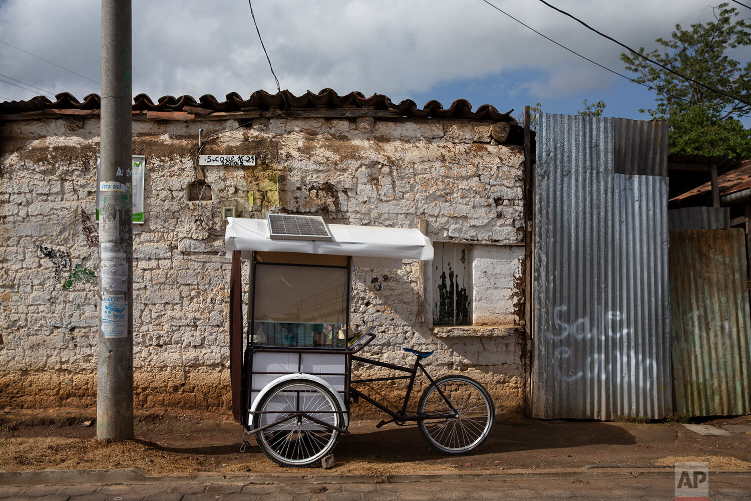  Teacher Gerardo Ixcoy sits parked just outside the doorway of a student's home, inside his secondhand adult tricycle he converted into a mobile classroom, in Santa Cruz del Quiche, Guatemala, Wednesday, July 15, 2020. Ixcoy has installed protective 