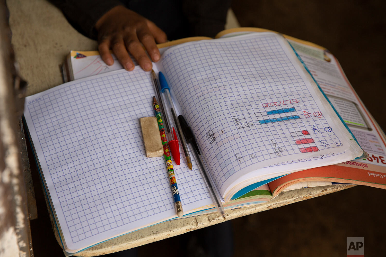  Oscar Rojas, 11, readies his notebooks, pens and pencils, as he prepares for the arrival of his teacher Gerardo Ixcoy, in Santa Cruz del Quiche, Guatemala, Wednesday, July 15, 2020. "I tried to get the kids their work sheets sending instructions via