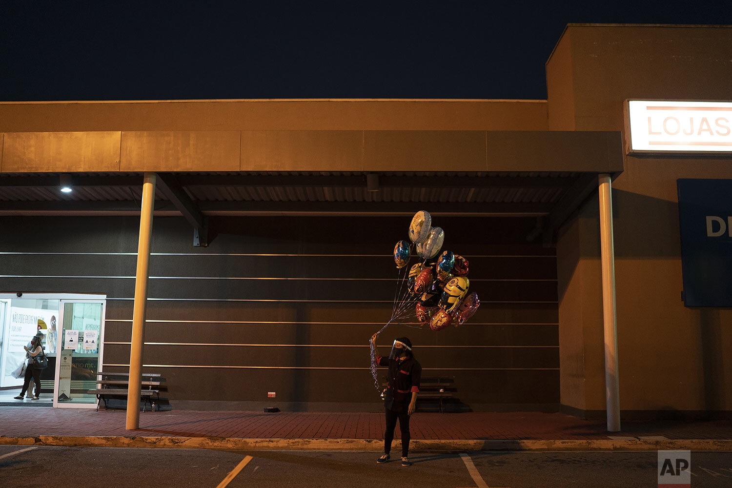  A circus vendor holds balloons  at the entrance of the Estoril Circus drive-in show in Itaguai, in greater Rio de Janeiro, Brazil, July 18, 2020. (AP Photo/Leo Correa) 
