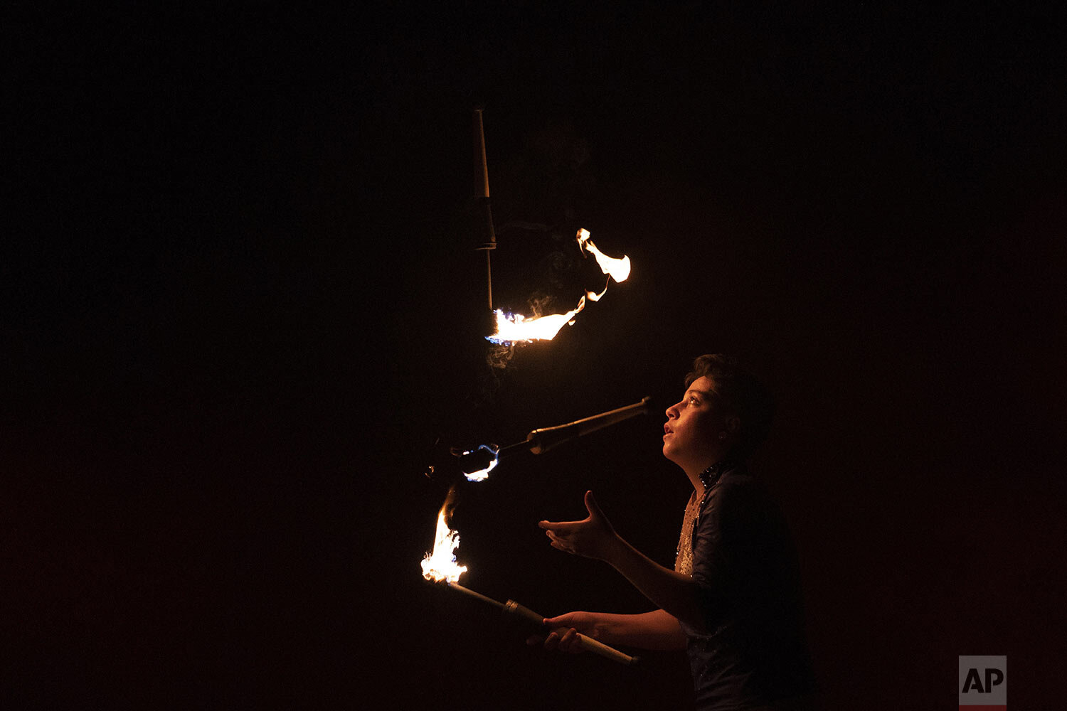  Lucas juggles with fire at the Estoril Circus drive-in show in Itaguai, in greater Rio de Janeiro, Brazil, July 18, 2020. (AP Photo/Leo Correa) 