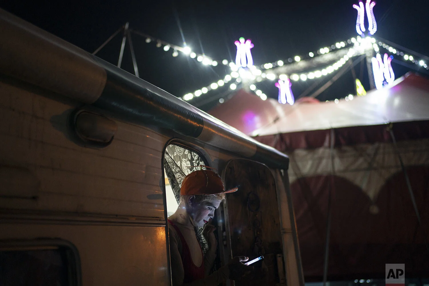  Clown “Pipoca,” or Edson Luan,  uses his cell to chat with a fellow clown who has COVID-19, before performing at the Estoril Circus drive-in show in Itaguai, in greater Rio de Janeiro, Brazil, Saturday, July 18, 2020. (AP Photo/Leo Correa) 