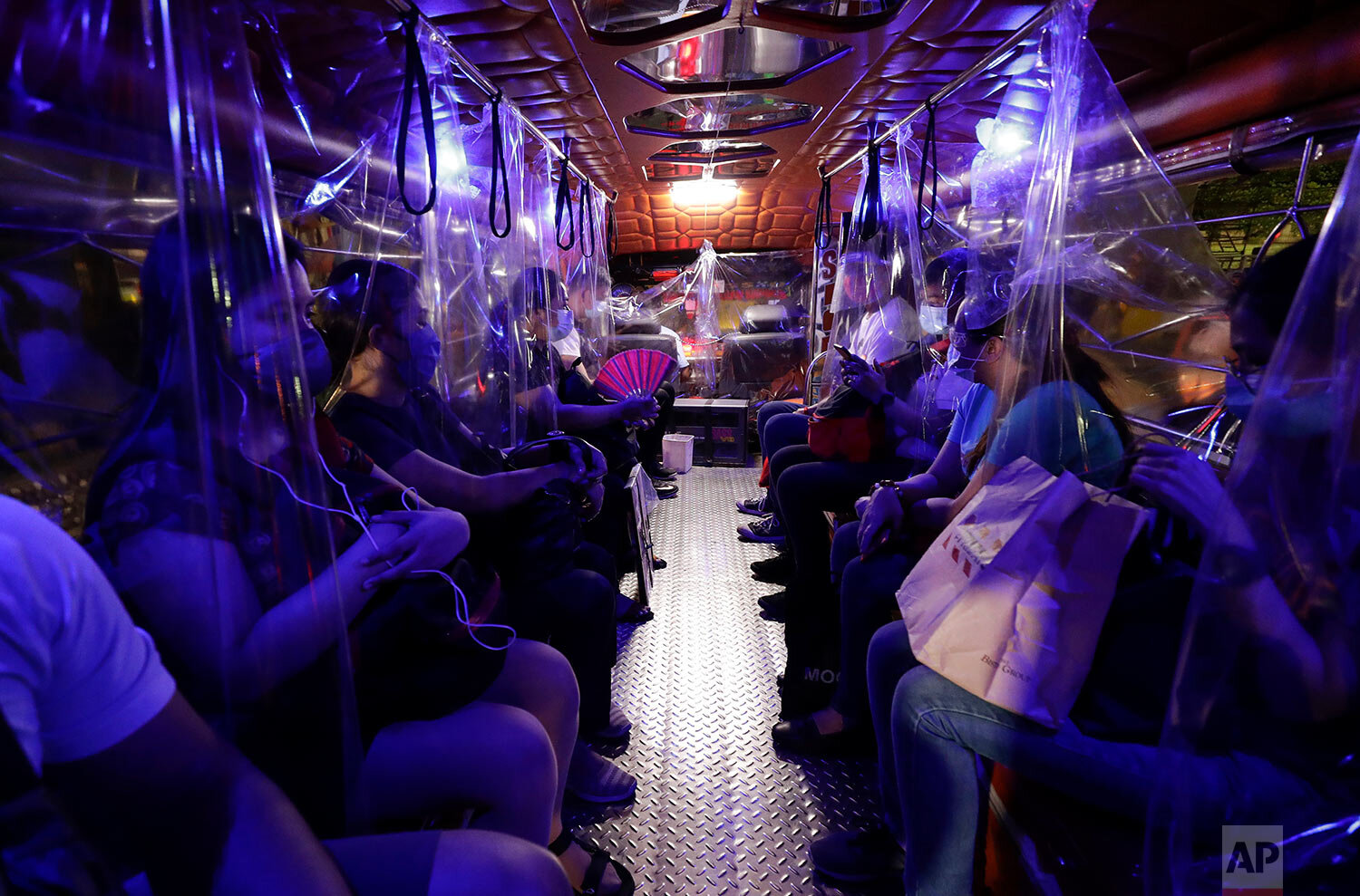  Plastic sheets on a traditional Jeepney bus separate passengers as part of health measures to help prevent the spread of the new coronavirus in metropolitan Manila, Philippines on Friday, July 3, 2020.  (AP Photo/Aaron Favila) 