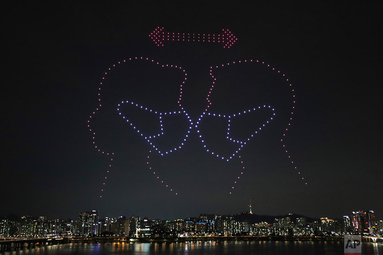 Some 400 drones fly over the Han River showing messages of appreciation for medical workers during the coronavirus pandemic in Seoul, South Korea on Saturday, July 4, 2020. (Lim Hwa-young/Yonhap via AP)
