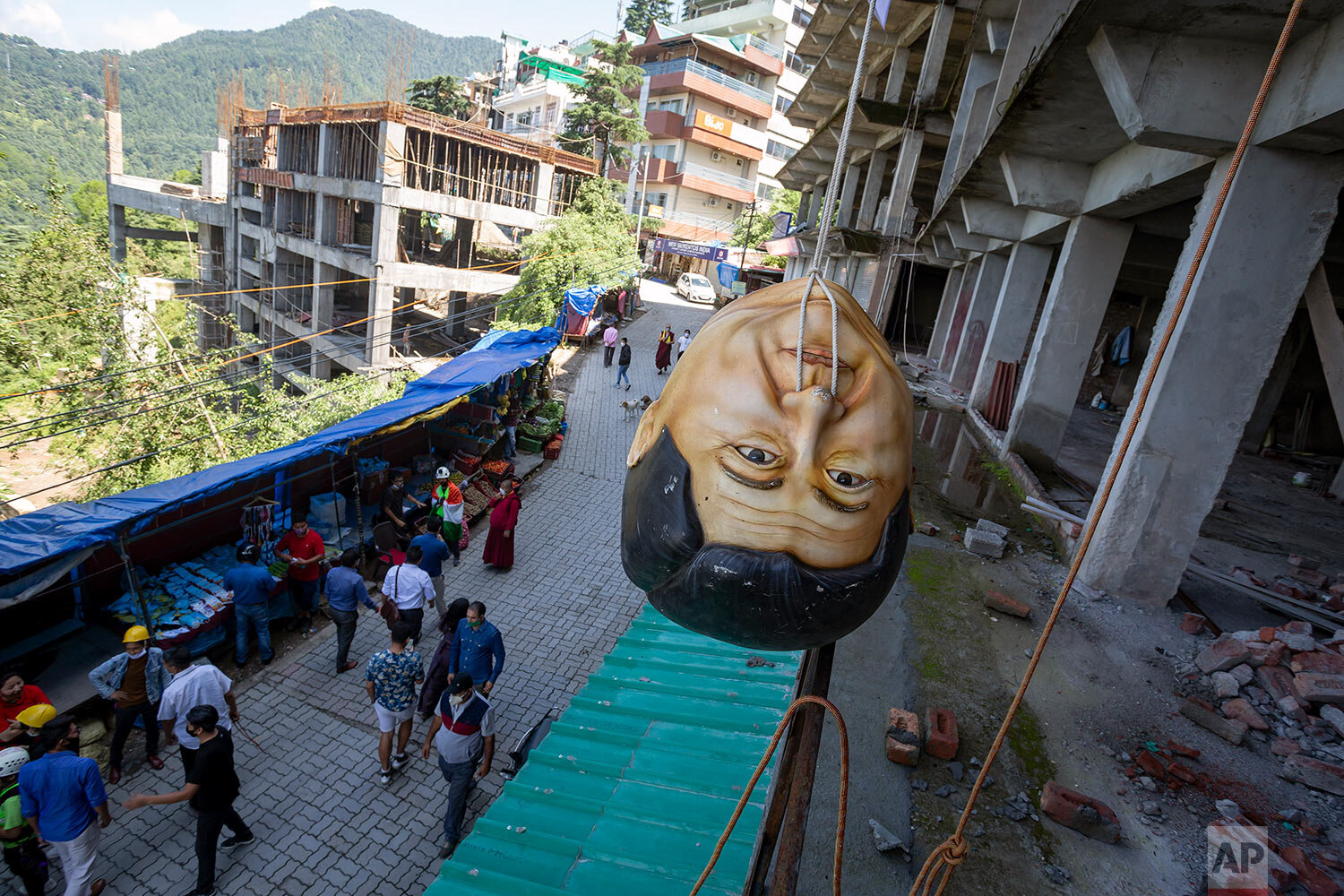  A model head in the likeness of Chinese President Xi Jinping is hung upside down from a building by Tibetan activists during a protest in Dharmsala, India, Thursday, July 23, 2020. (AP Photo/Ashwini Bhatia) 