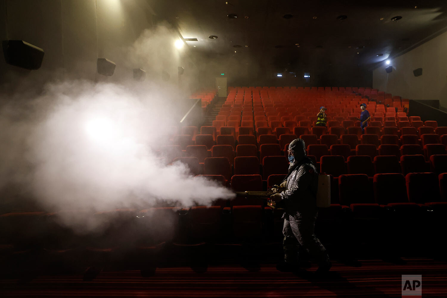  A volunteer with the Blue Sky Rescue team performs disinfecting of a theater before it reopens for business in Beijing Friday, July 24, 2020. (AP Photo/Ng Han Guan) 