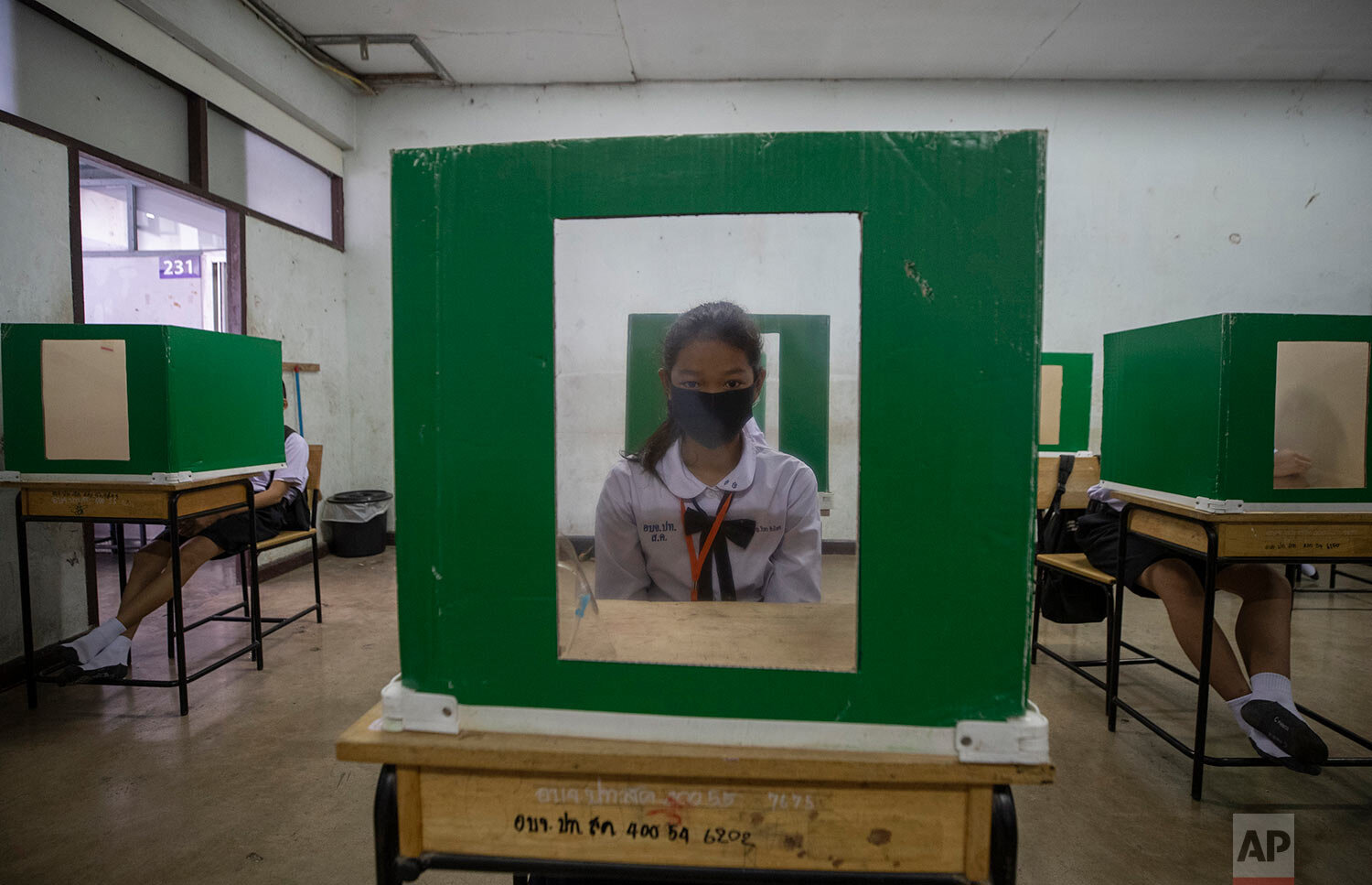  A student sits at her partitioned desk in a classroom at the Samkhok School in Pathum Thani, outside Bangkok, Wednesday, July 1, 2020. (AP Photo/Sakchai Lalit) 