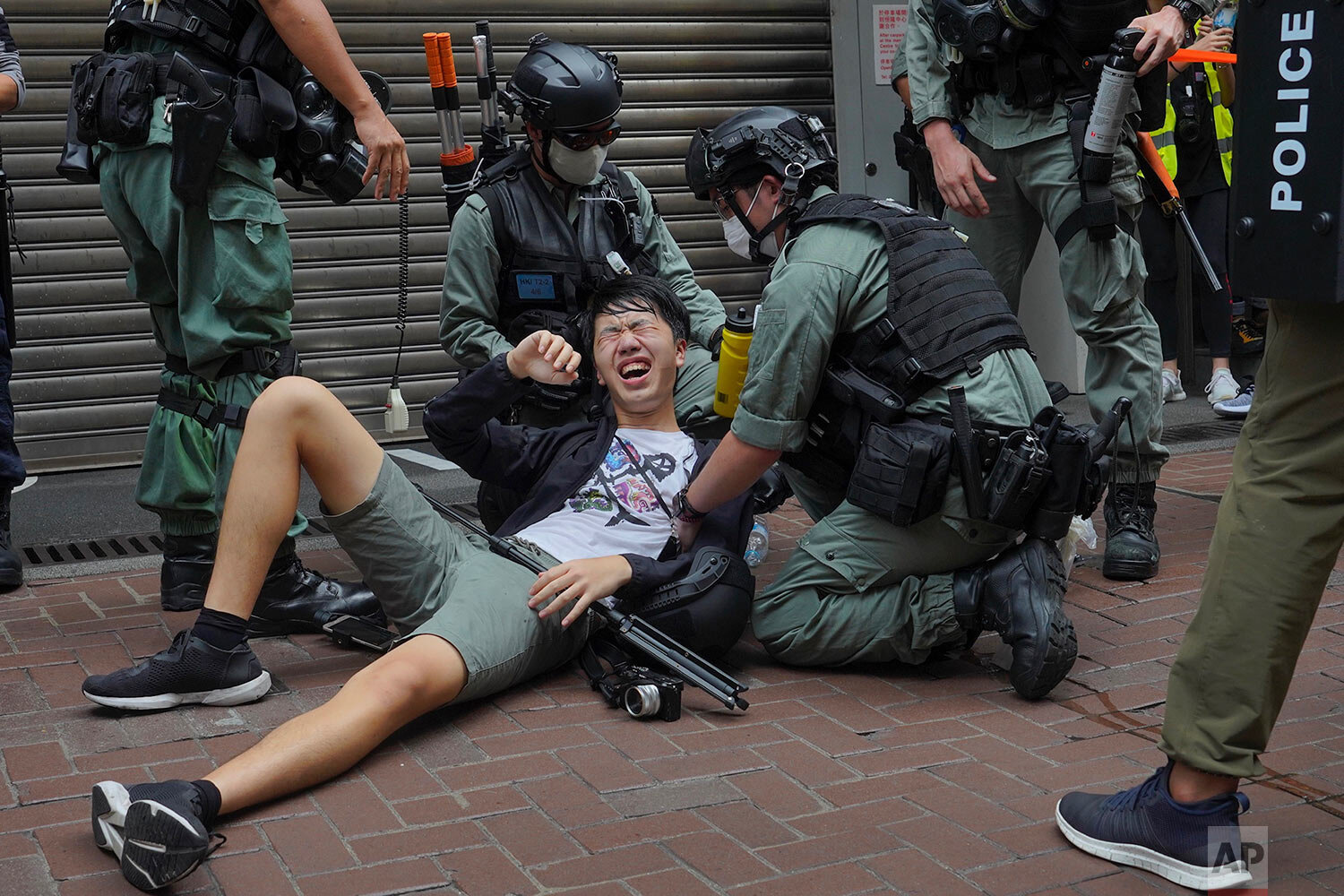  A reporter falls down after being sprayed with pepper spray by police during a protest in Causeway Bay during the annual handover march in Hong Kong, Wednesday, July. 1, 2020.  (AP Photo/Vincent Yu) 