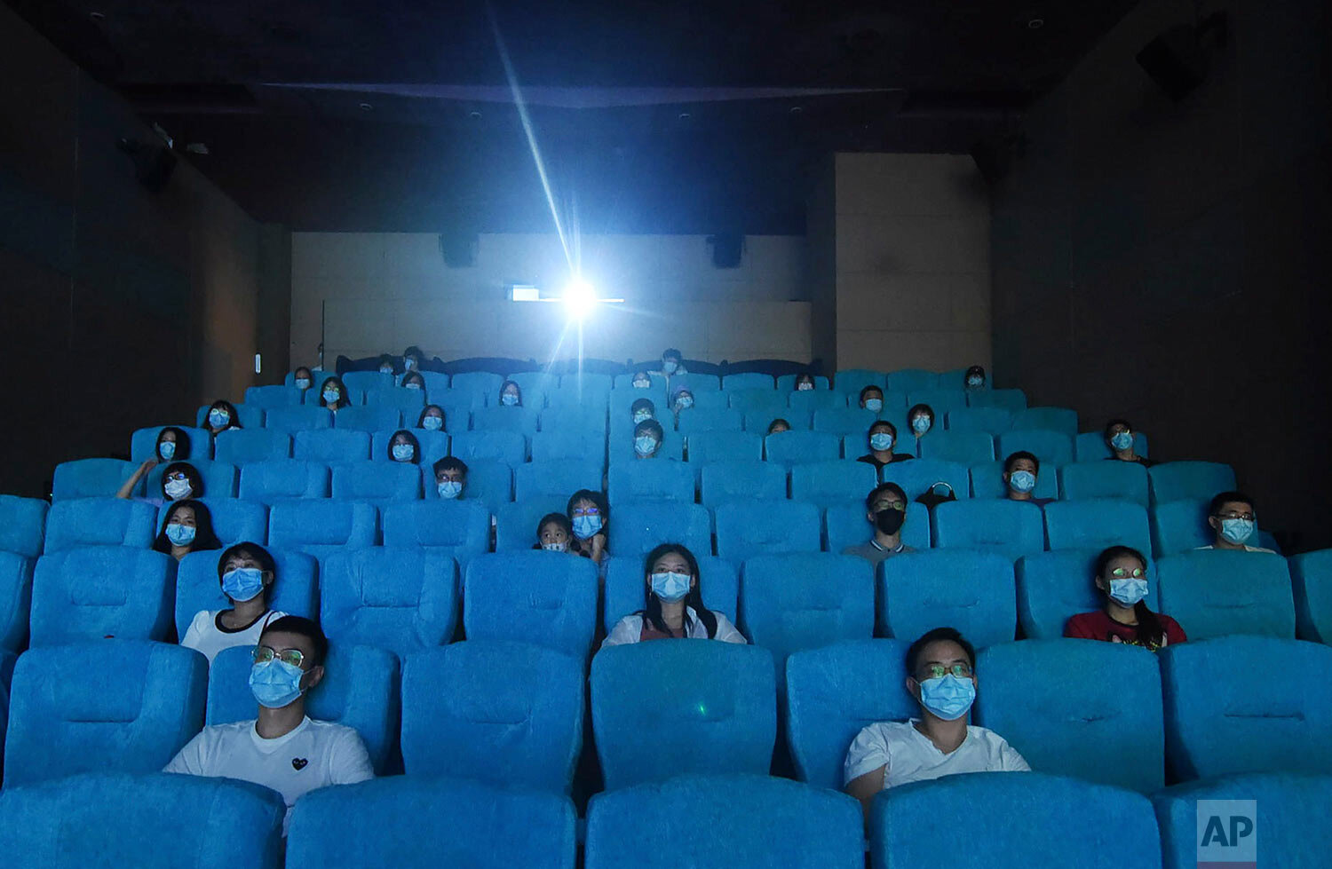  Movie-goers wearing masks to protect themselves from the coronavirus are spaced apart as they watch a movie in a newly reopened cinema in Hangzhou in eastern China's Zhejiang province on Monday, July 20, 2020.  (Chinatopix via AP) 