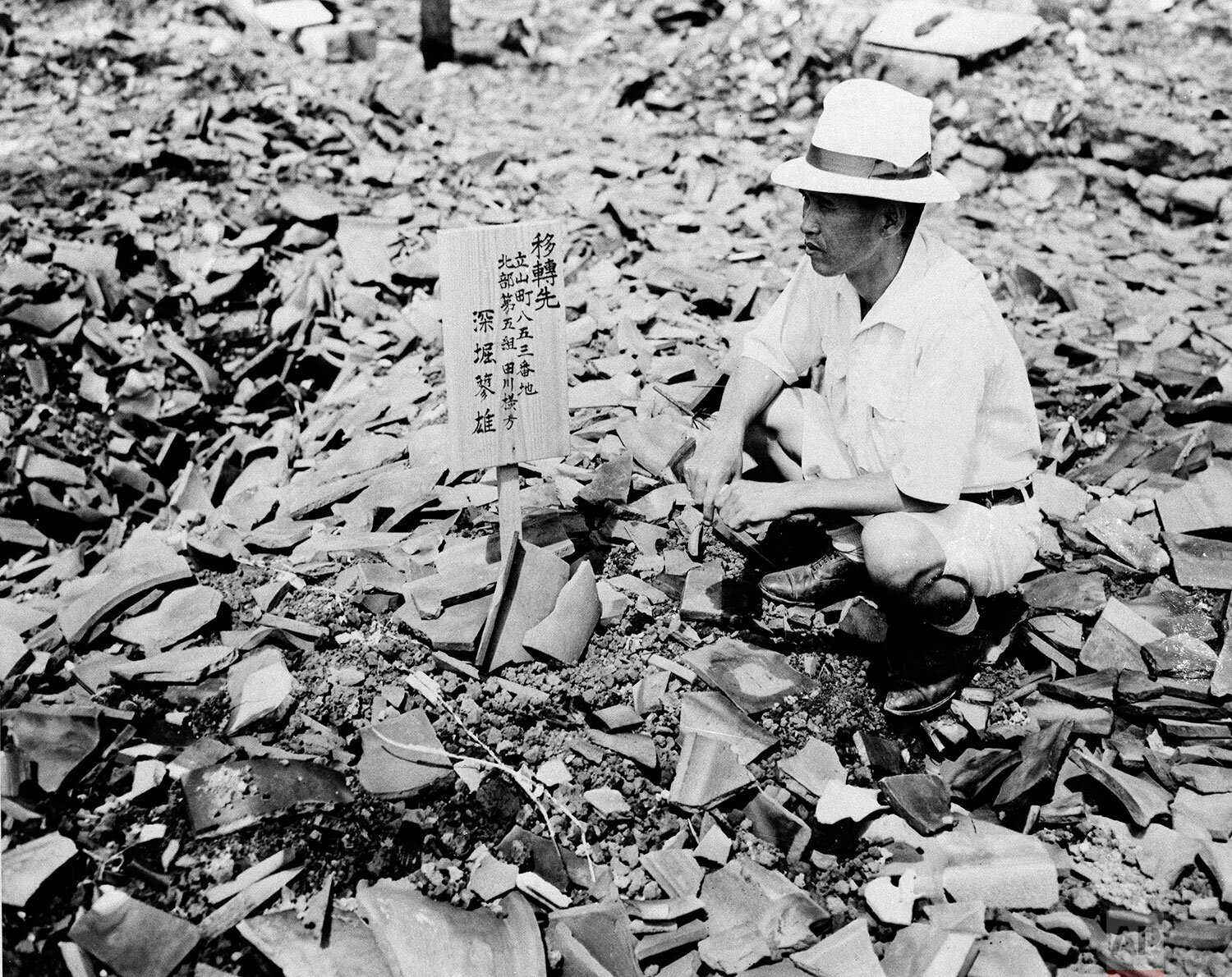  A civilian examines a sign in the middle of mass of rubble that once was a home in Nagasaki, Sept 14, 1945, one of the cities destroyed by atomic bomb. (AP Photo) 