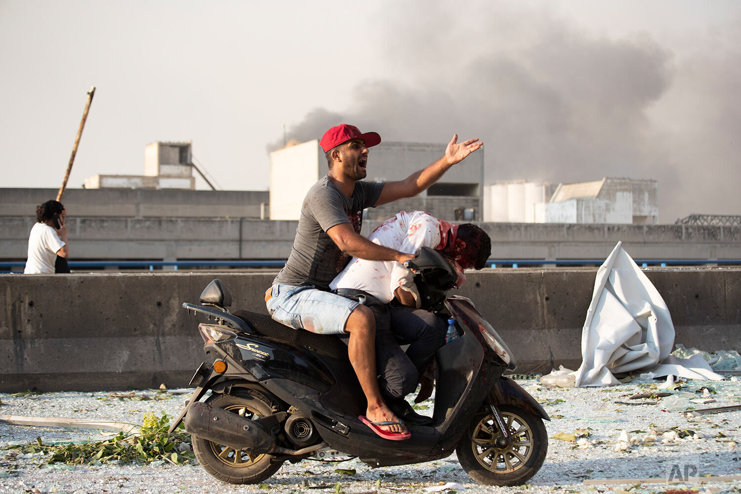  A man evacuates an injured person after a massive explosion in Beirut, Lebanon, Tuesday, Aug. 4, 2020. (AP Photo/Hassan Ammar) 