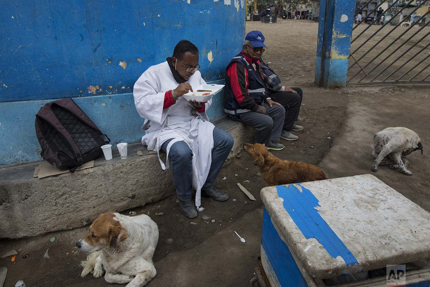  Brother Ronald Marin enjoys a free lunch between burials, at the entrance of the “Martires 19 de Julio” cemetery in Comas, on the outskirts of Lima, Peru, Friday, July 17, 2020. (AP Photo/Rodrigo Abd) 