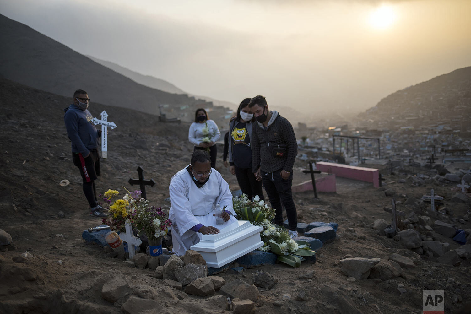 Brother Ronald Marin prays over the coffin that contains the remains of Keizer Quinones and Sarai Araujo’s unborn daughter, at a burial service in the “Martires 19 de Julio” cemetery in Comas, on the outskirts of Lima, Peru, Tuesday, July 21, 2020. 