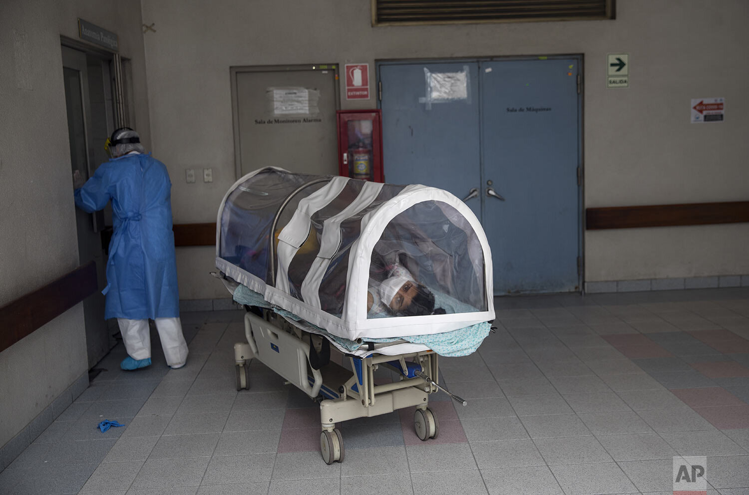  A woman looks out from a coronavirus isolation pod as she is transferred to a special ward for mothers with COVID-19 at the National Perinatal and Maternal Institute in Lima, Peru, Wednesday, July 29, 2020. (AP Photo/Rodrigo Abd) 