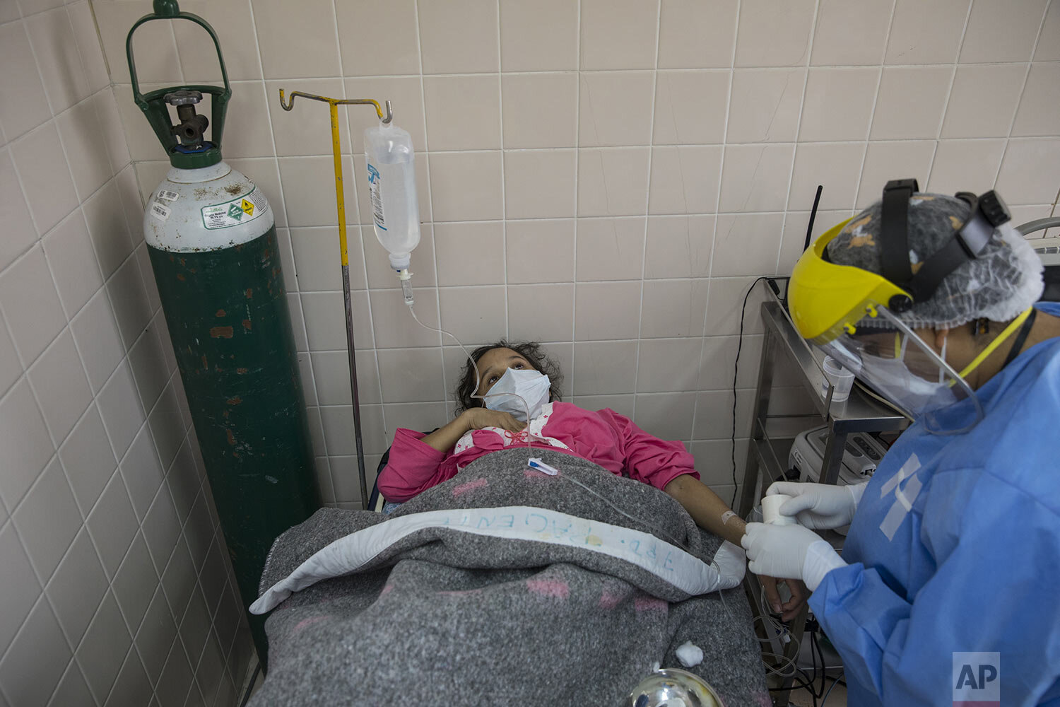  Maria Alvarez, 24, nine months pregnant, lies on an examination table in an isolated holding area of the National Perinatal and Maternal Institute reserved for women in labor infected with the new coronavirus, in Lima, Peru, Wednesday, July 29, 2020