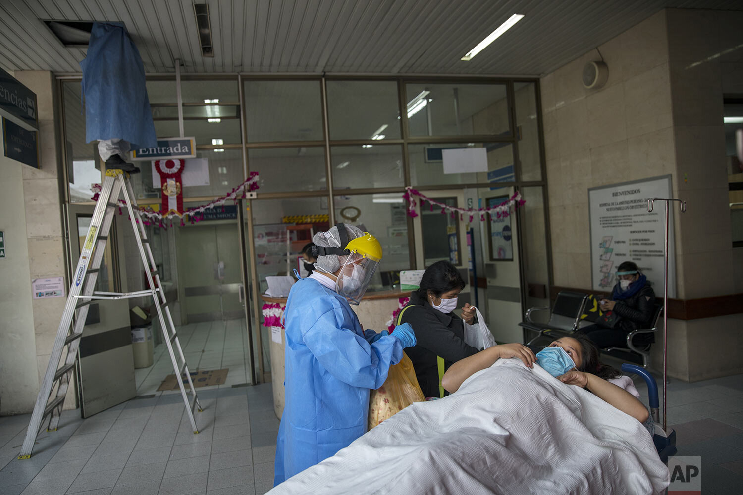  A nurse admits an expectant mother who tested positive for the new coronavirus at an entry checkpoint set up outside the emergency entrance of the National Maternal Perinatal Institute, in Lima, Peru, Wednesday, July 29, 2020. (AP Photo/Rodrigo Abd)