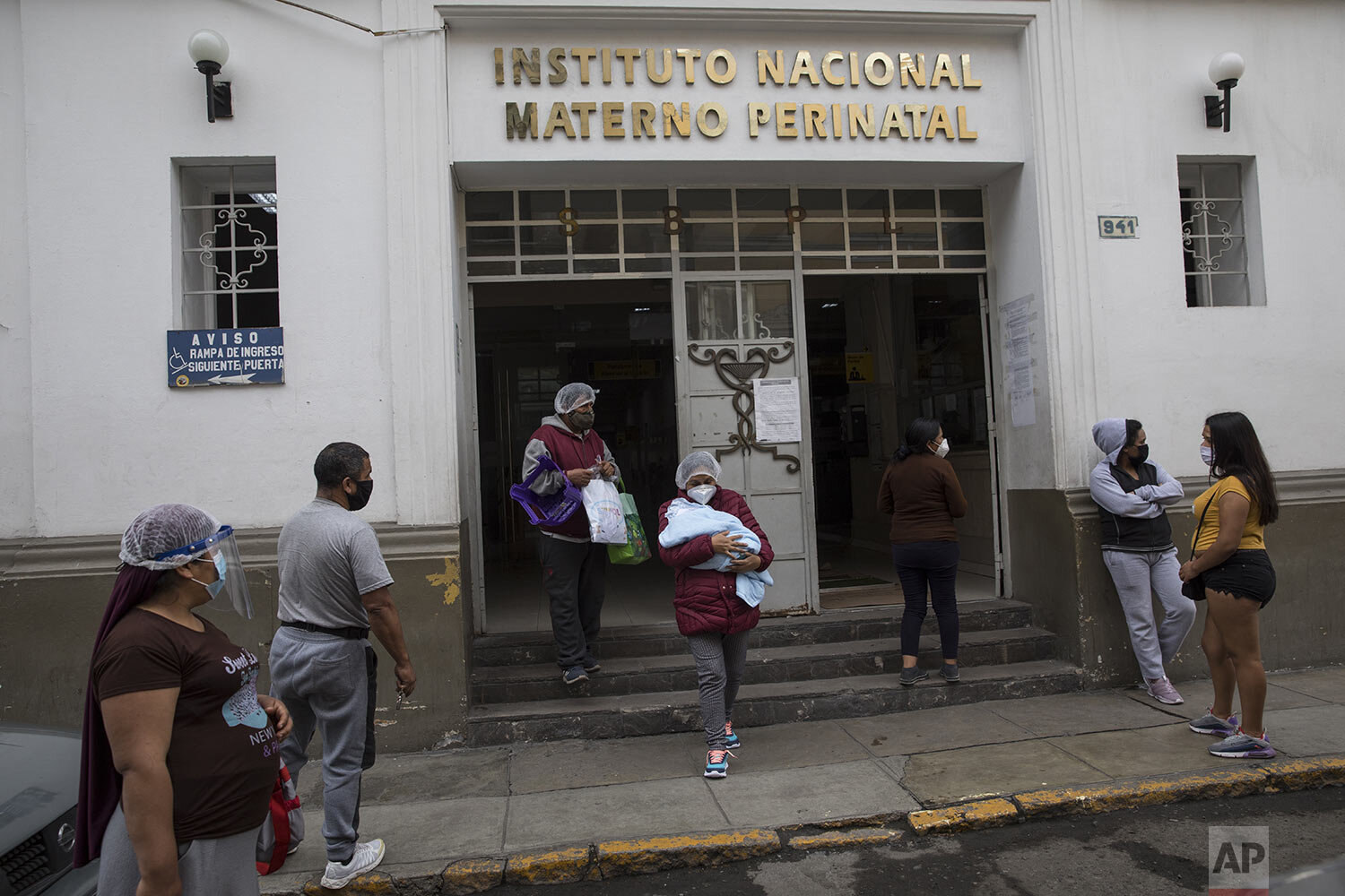  Accompanied by her husband, Carmen Garcia, 43, cradles her newborn baby delivered in a special ward for mothers with COVID-19, as they leave the National Maternal Perinatal Institute, in Lima, Peru, Thursday, July 9, 2020. (AP Photo/Rodrigo Abd) 