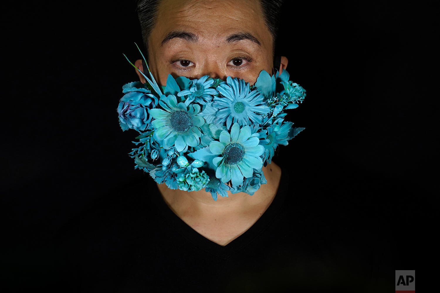  Edmond Kok, a Hong Kong theater costume designer and actor, wearing a face mask covered in blue artificial flowers which he made on Valentine's Day this February in Hong Kong Thursday, Aug. 6, 2020. (AP Photo/Vincent Yu) 