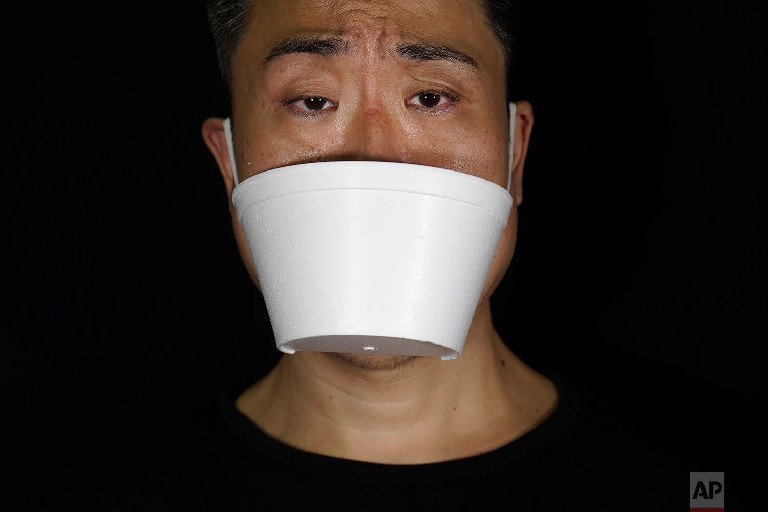  Edmond Kok, a Hong Kong theater costume designer and actor, wearing a face mask made from takeaway container in Hong Kong Thursday, Aug. 6, 2020. (AP Photo/Vincent Yu) 