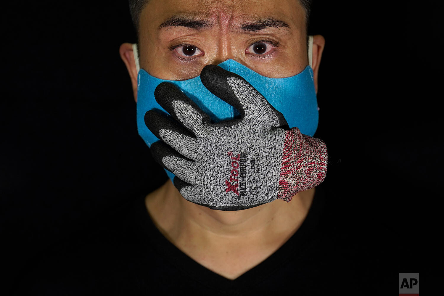  Edmond Kok, a Hong Kong theater costume designer and actor, wearing a face mask designed with a stuffed glove stuck on it, representing a hand over his mouth, looking scared, in Hong Kong Thursday, Aug. 6, 2020. (AP Photo/Vincent Yu) 