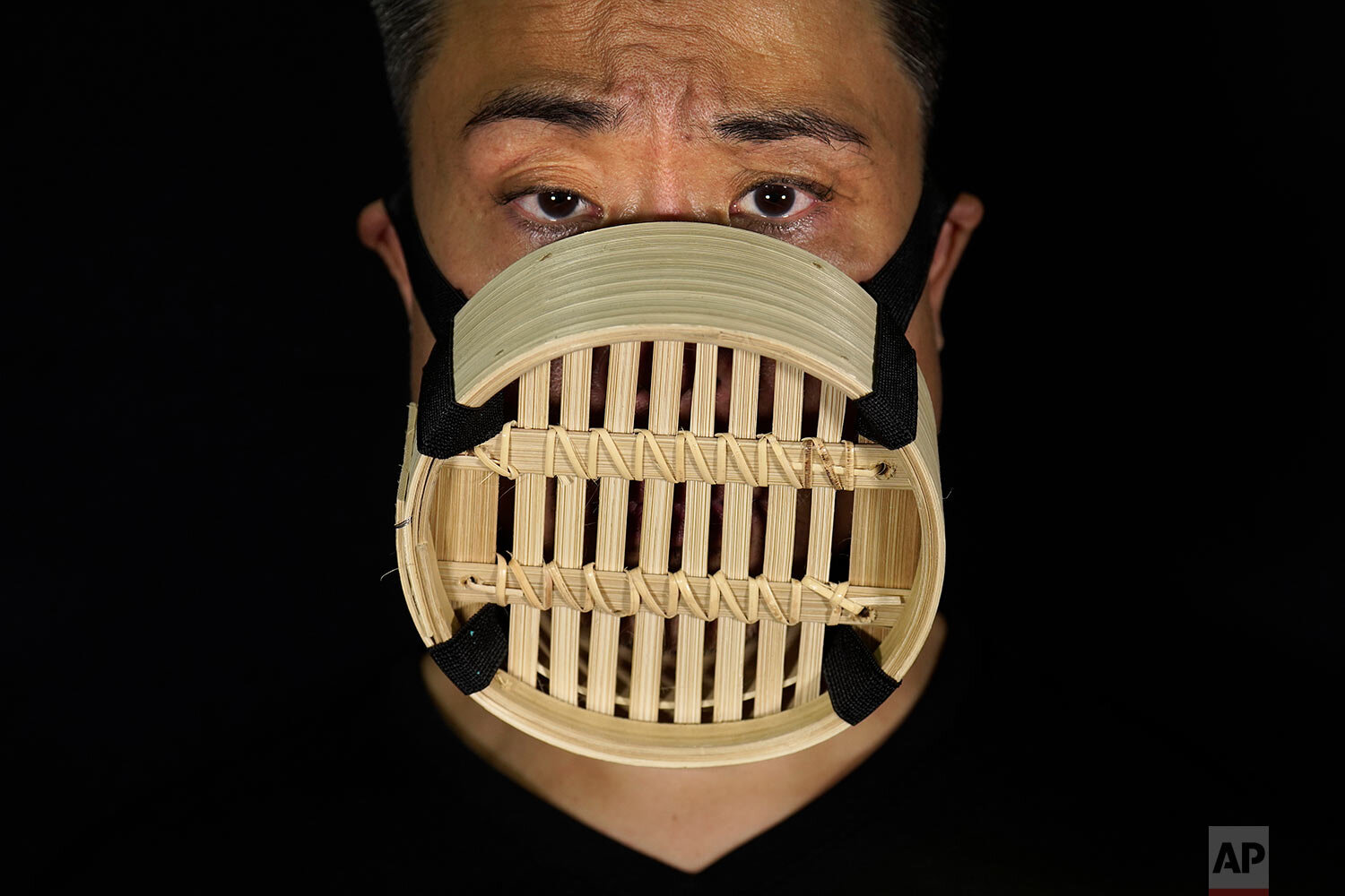  Edmond Kok, a Hong Kong theater costume designer and actor, wearing a face mask made from Chinese bamboo steamer in Hong Kong Thursday, Aug. 6, 2020. (AP Photo/Vincent Yu) 
