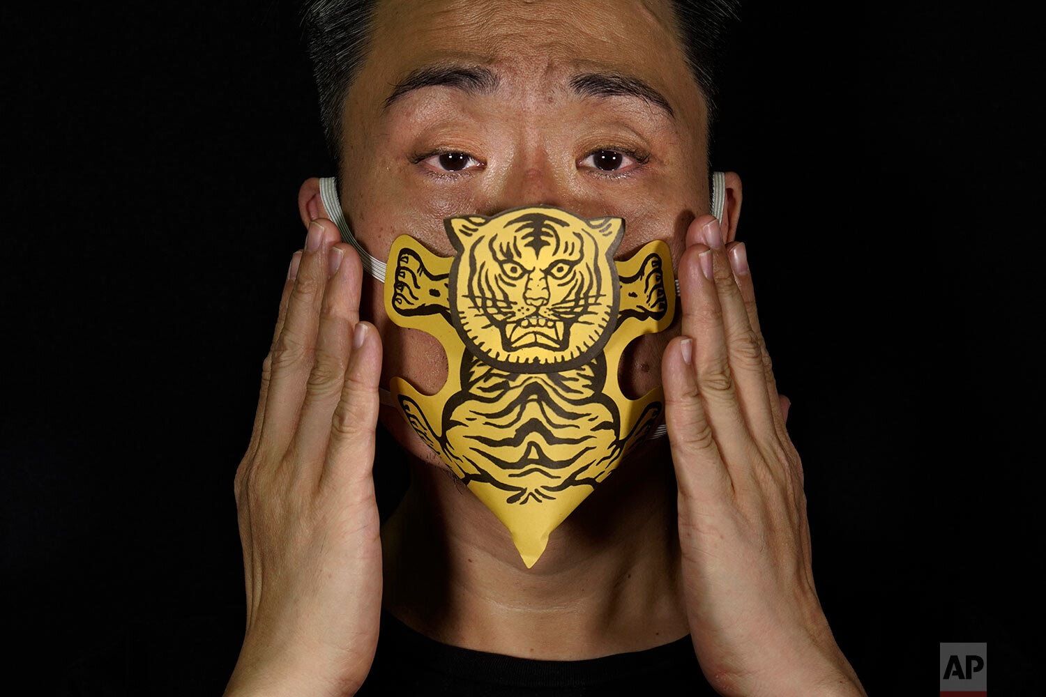  Edmond Kok, a Hong Kong theater costume designer and actor, wearing a face mask made by a paper tiger use for villain hitting in Hong Kong Thursday, Aug. 6, 2020. (AP Photo/Vincent Yu) 