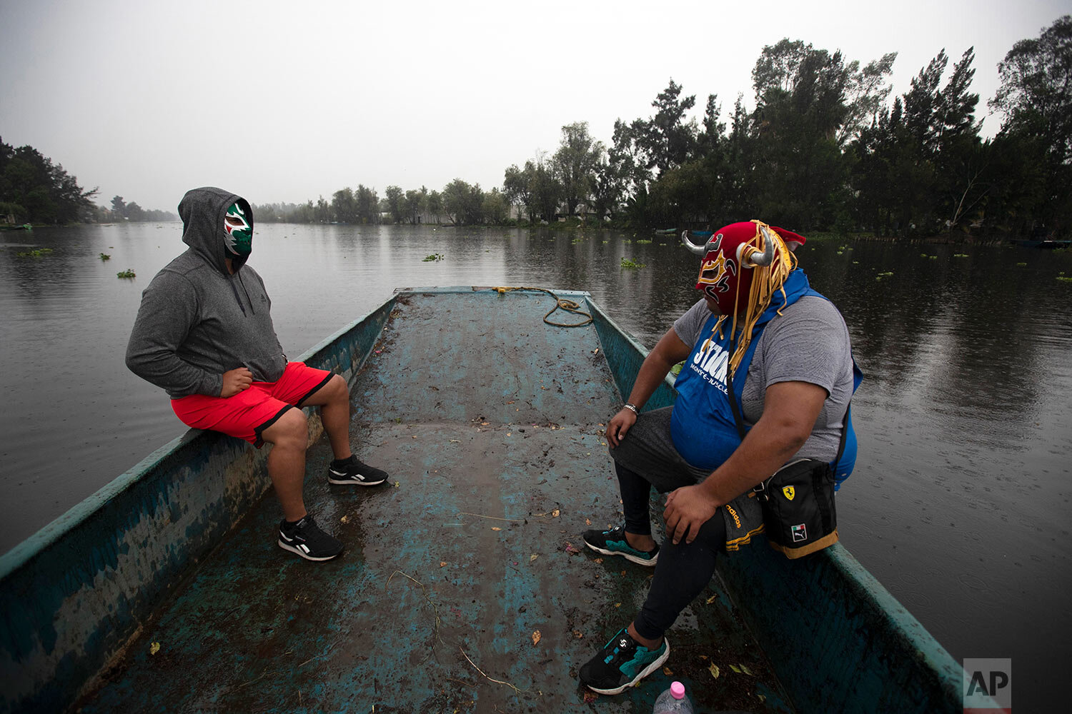  Lucha Libre brothers, "Ciclonico," or Cyclonic, left, and Mister Jerry, ride a boat to their training site on Xochimilco's famous floating gardens on the outskirts of Mexico City, early Aug. 20, 2020, amid COVID-19 that has closed wrestling halls. (