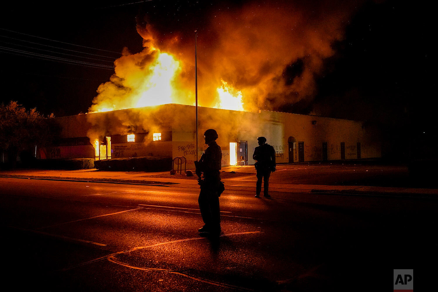  Police stand near a department of corrections building that was on fire during protests, Monday, Aug. 24, 2020, in Kenosha, Wis., sparked by the shooting of Jacob Blake by a Kenosha Police officer a day earlier. (AP Photo/Morry Gash) 