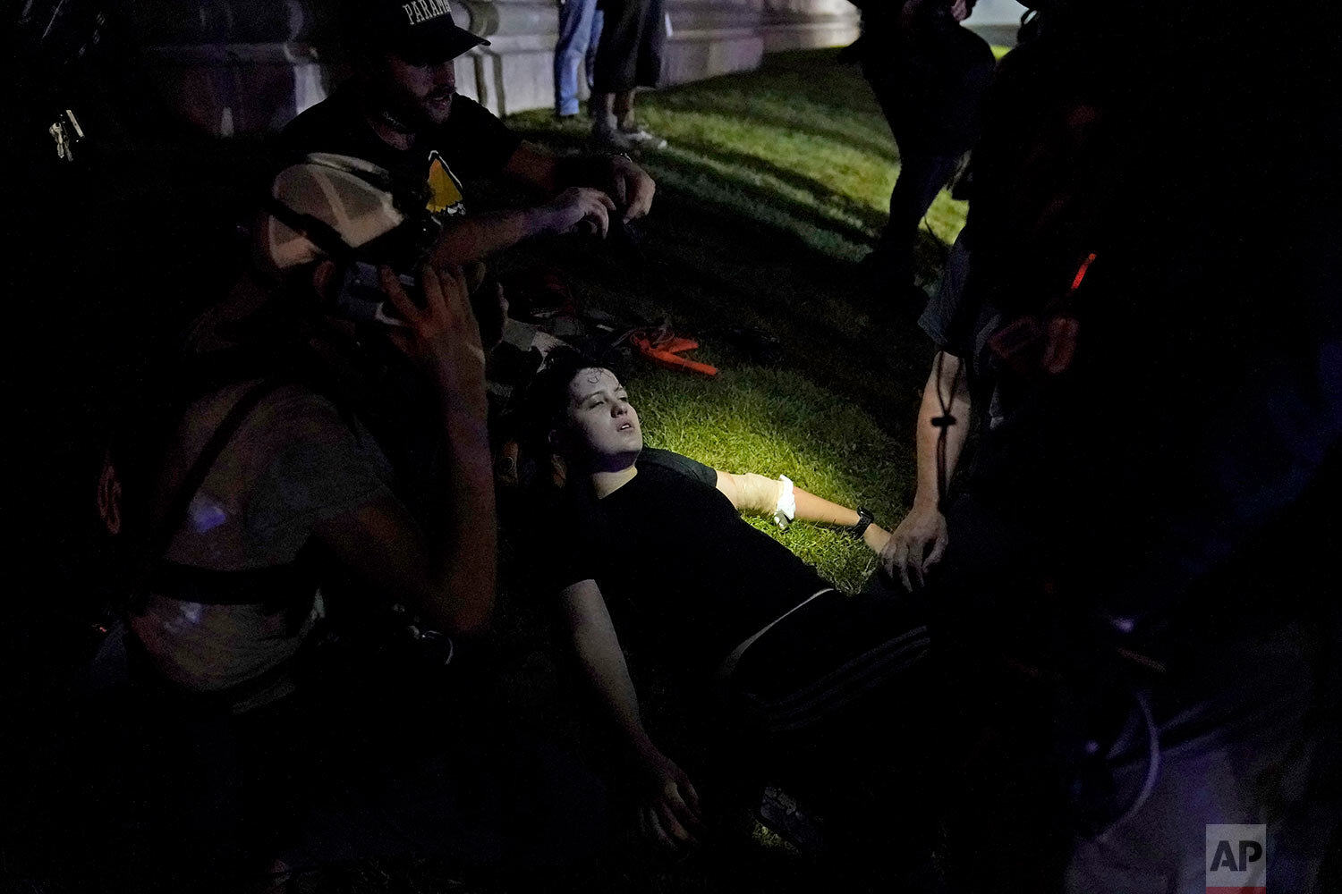  A protester lays injured during clashes with police outside the Kenosha County Courthouse late Tuesday, Aug. 25, 2020, in Kenosha, Wis. (AP Photo/David Goldman) 