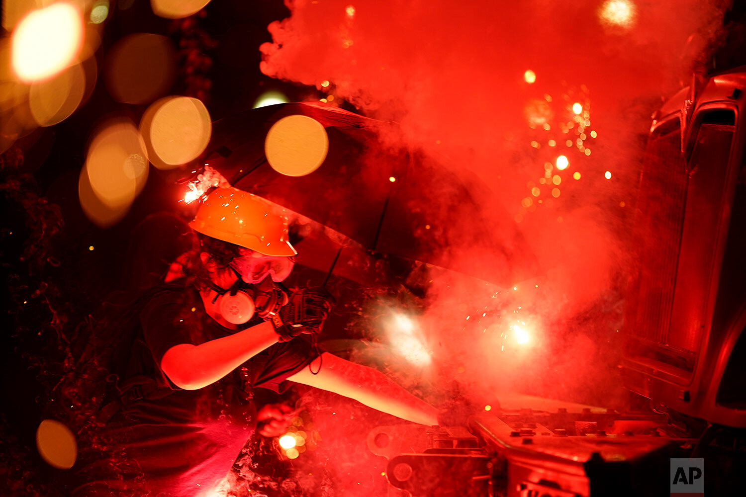  An explosive device detonates as a protester pushes back on an armored vehicle clearing the park of demonstrators during clashes outside the Kenosha County Courthouse, late Tuesday, Aug. 25, 2020, in Kenosha, Wis. (AP Photo/David Goldman) 