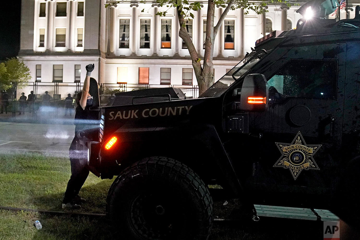  A protester obstructs an armored vehicle attempting to clear the park of demonstrators during clashes outside the Kenosha County Courthouse late Tuesday, Aug. 25, 2020, in Kenosha, Wis.  (AP Photo/David Goldman) 